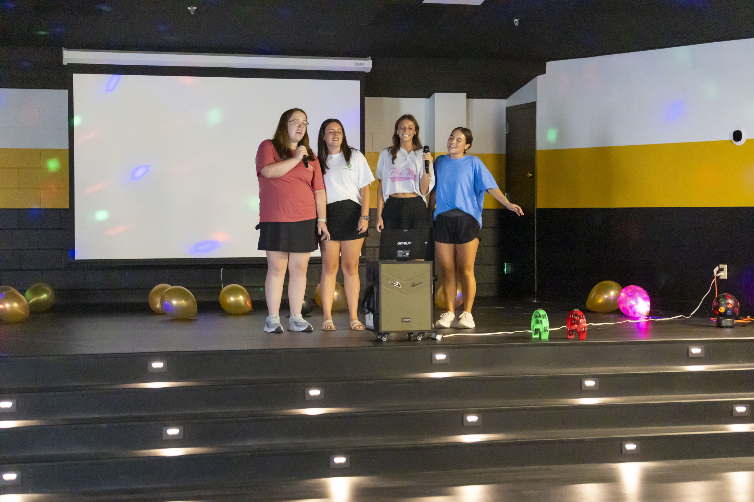 Four students singing karaoke in renovated SUB.