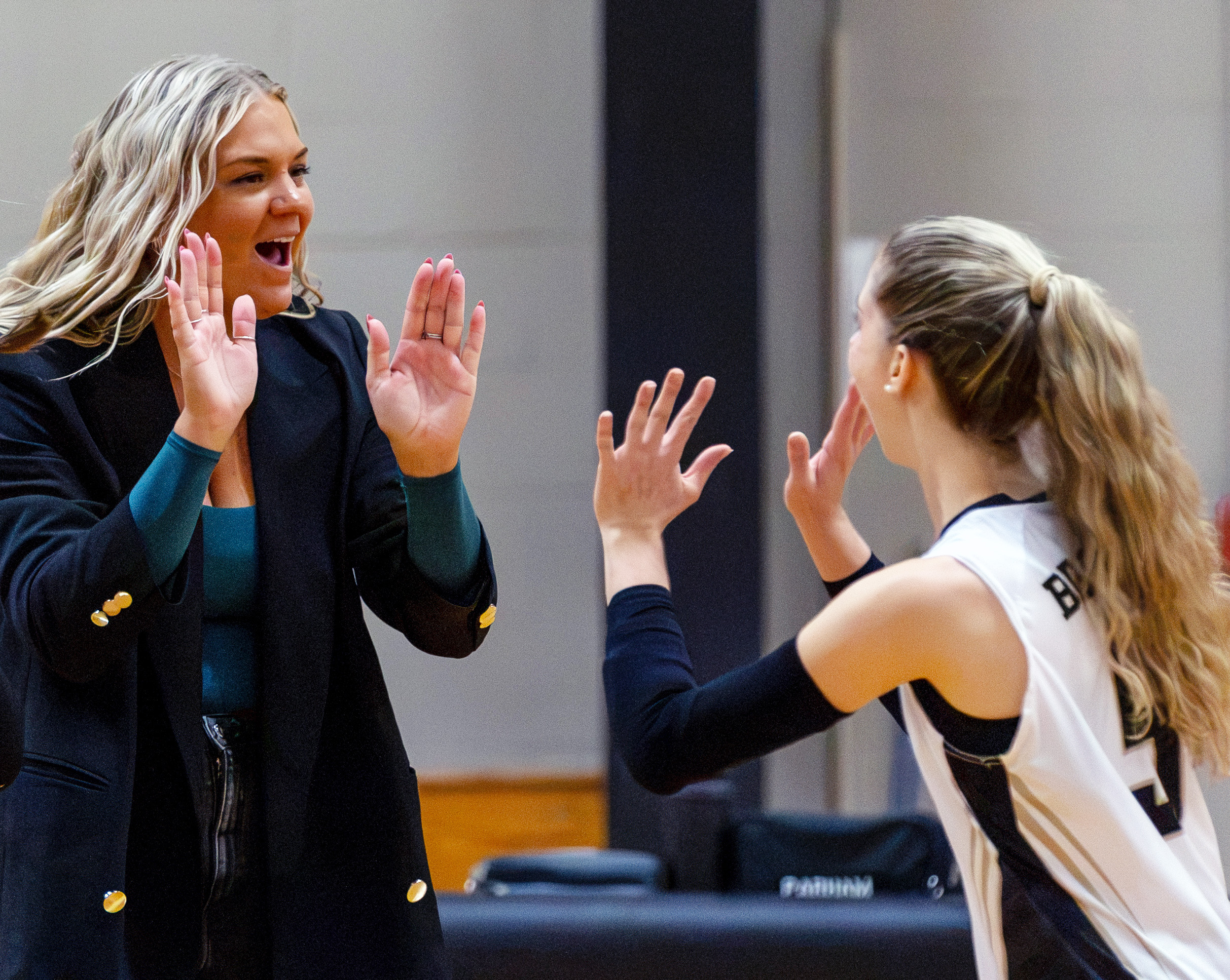Coach Kalmink high-fives a member of the volleyball team